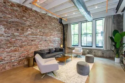 a living room with a couch and a brick wall at Inventors' Loft - Stay in the Heart of it All in Philadelphia