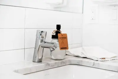 a bottle of soap sitting on a kitchen sink at Inventors' Loft - Stay in the Heart of it All in Philadelphia