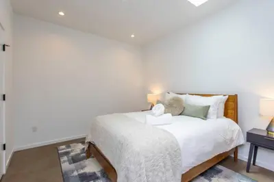 a white bedroom with a bed and a table at Inventors' Loft - Stay in the Heart of it All in Philadelphia