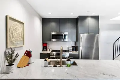 a kitchen with a sink and stainless steel appliances at Inventors' Loft - Stay in the Heart of it All in Philadelphia