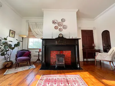 a living room with a fireplace with a red brick at The Borland House Inn in Montgomery
