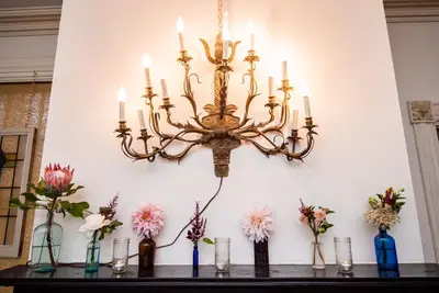 a chandelier hanging over a table with vases of flowers at The Borland House Inn in Montgomery