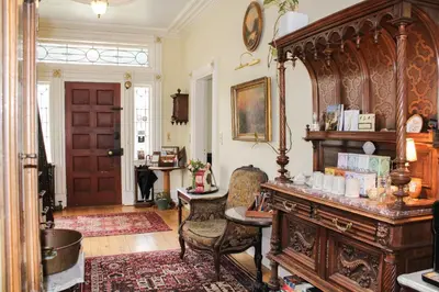 a room with a large wooden table and a chair at The Borland House Inn in Montgomery