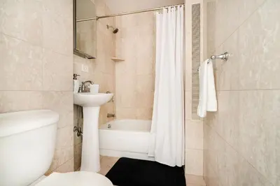 a bathroom with a tub and a sink and a toilet at 73-819 New Studio UWS Doorman Gym in New York