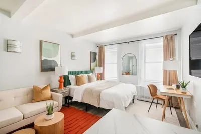 a white bedroom with a bed and a couch at 73-819 New Studio UWS Doorman Gym in New York