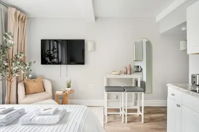 a white bedroom with a bed and a kitchen at 73-919 New Studio UWS Doorman Gym in New York