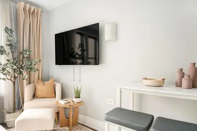 a living room with a chair and a tv on a wall at 73-919 New Studio UWS Doorman Gym in New York