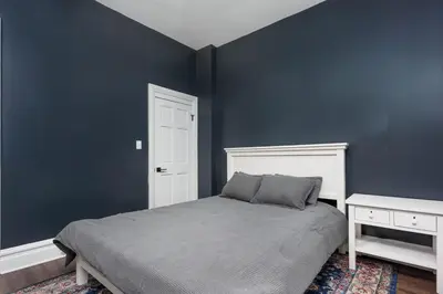 a bedroom with a bed and a blue wall at Flats on Front - Riverfront Gem Fast Wi-Fi 2F in Harrisburg