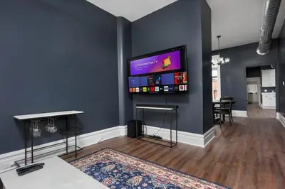 a living room with a flat screen tv on a wall at Flats on Front - Riverfront Gem Fast Wi-Fi 2F in Harrisburg