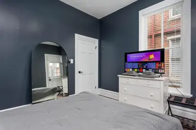 a bedroom with a bed and a tv on a dresser at Flats on Front - Riverfront Gem Fast Wi-Fi 2F in Harrisburg