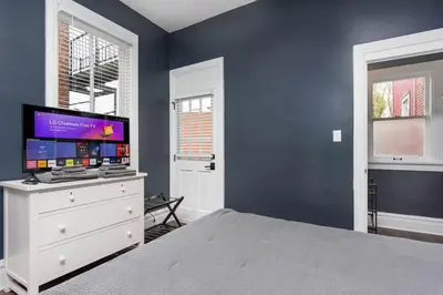 a bedroom with a bed and a tv on a dresser at Flats on Front - Riverfront Gem Fast Wi-Fi 2F in Harrisburg