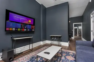 a living room with a flat screen tv on a wall at Flats on Front - Riverfront Gem Fast Wi-Fi 1F in Harrisburg