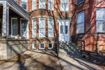 an old brick house with a white door at Flats on Front - Riverfront Gem Fast Wi-Fi 1F in Harrisburg