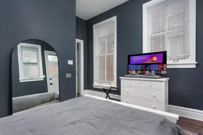 a bedroom with a bed and a tv on a dresser at Flats on Front - Riverfront Gem Fast Wi-Fi 1F in Harrisburg