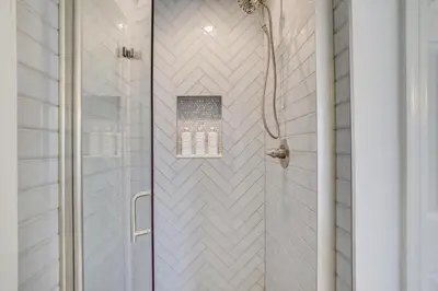 a shower with a glass door and white tiles at 30 Day Minimum Stay - Private Creekside Solace in East Stroudsburg