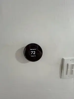 a black alarm clock on a white wall at 4 Bedroom Apartment in Hillside