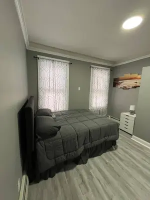 a bedroom with a bed and a television in it at 4 Bedroom Apartment in Hillside