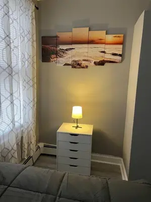 a bedroom with a bed and a table with a lamp at 4 Bedroom Apartment in Hillside