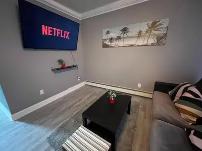 a living room with a couch and a table at 4 Bedroom Apartment in Hillside