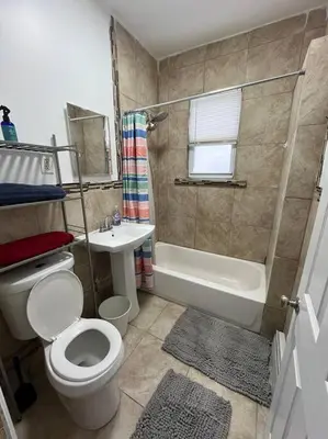 a bathroom with a toilet and a shower and a sink at 4 Bedroom Apartment in Hillside
