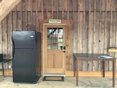 a refrigerator and a table in front of a door at The Lodge by Towanda and Sayre PA in Ulster
