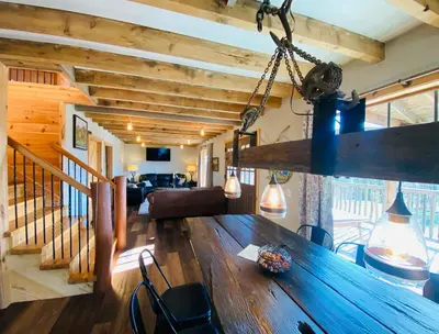 a dining room and living room with a large wooden table at The Lodge by Towanda and Sayre PA in Ulster