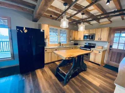 a kitchen with a wooden table and a black refrigerator at The Lodge by Towanda and Sayre PA in Ulster