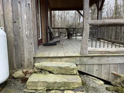 a porch of a cabin with a table and chairs at Mighty Oak near Sayre Towanda in Ulster