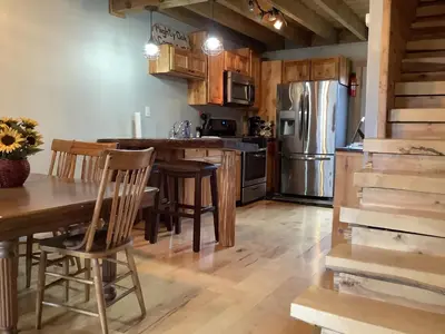 a kitchen with a table and a stainless steel refrigerator at Mighty Oak near Sayre Towanda in Ulster