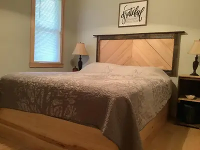a bedroom with a large bed with a wooden headboard at Mighty Oak near Sayre Towanda in Ulster