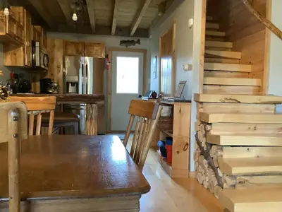 a kitchen with a wooden table and a staircase at Mighty Oak near Sayre Towanda in Ulster