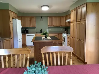 a kitchen with wooden cabinets and a table and chairs at StoneBrook Haven near Guthrie RPH Towanda Campus in Ulster