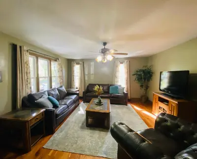 a living room with leather couches and a tv at StoneBrook Haven near Guthrie RPH Towanda Campus in Ulster