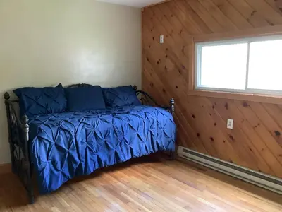 a bedroom with a bed with blue sheets and a window at StoneBrook Haven near Guthrie RPH Towanda Campus in Ulster