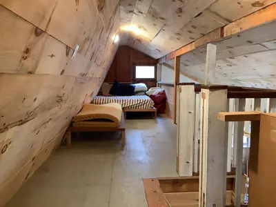 a room with two beds and a wall of wood at Willow Point Cabin Brenchly Lake in Ulster