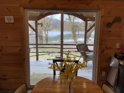 a dining room with a table and a large sliding glass door at Willow Point Cabin Brenchly Lake in Ulster