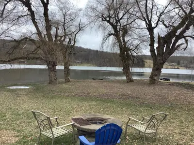 two chairs and a table next to a lake at Willow Point Cabin Brenchly Lake in Ulster