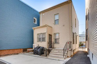 a house with a staircase next to a building at Jersey City Apartment with Game Room 7 Mi to NYC! in Jersey City