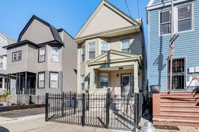 a house with a fence in front of it at Jersey City Apartment with Game Room 7 Mi to NYC! in Jersey City