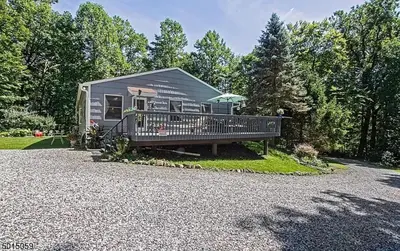 a tiny house with a porch and a deck at Large Private House on 5 Wooded Acres. Total Privacy! in Hackettstown