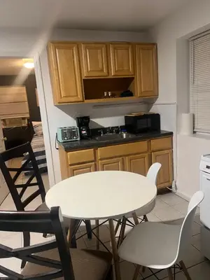 a small kitchen with a white table and chairs at Serenity Cove -2 Bedroom Apartment in Newark