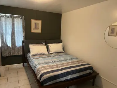 a bed in a room with a green wall at Serenity Cove -2 Bedroom Apartment in Newark