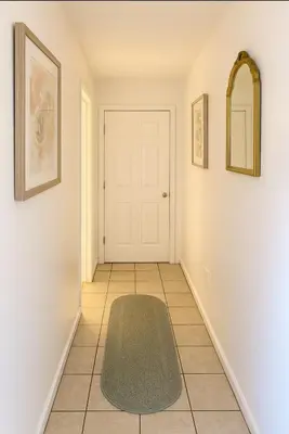 a hallway with a white door and a green rug at Serenity Cove -2 Bedroom Apartment in Newark