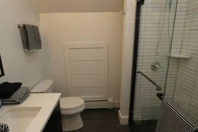 a bathroom with a toilet and a glass shower at Modern Chalet with Hot Tub and Lake Access in Monticello