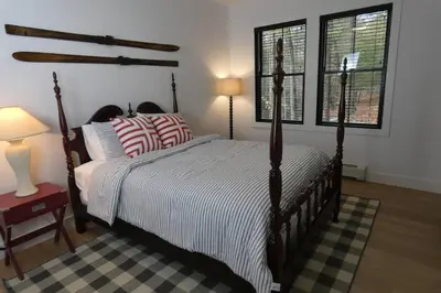 a bedroom with a large bed with striped pillows at Modern Chalet with Hot Tub and Lake Access in Monticello