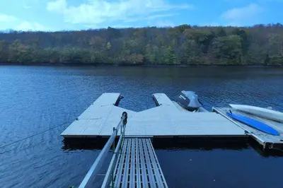 a dock on a lake with two boats on it at Modern Chalet with Hot Tub and Lake Access in Monticello