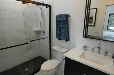 a bathroom with a shower and a toilet and a sink at Modern Chalet with Hot Tub and Lake Access in Monticello