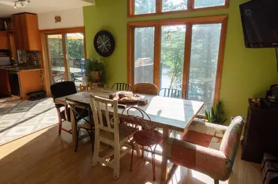 a dining room with a wooden table and chairs at Whimsical Lakefront Chalet in Monticello