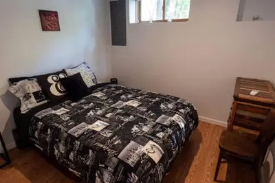 a bedroom with a bed with a black and white quilt at Whimsical Lakefront Chalet in Monticello