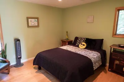 a bedroom with a bed with a mask on it at Whimsical Lakefront Chalet in Monticello